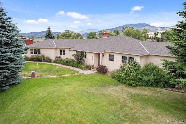 view of front of home with a mountain view and a front lawn