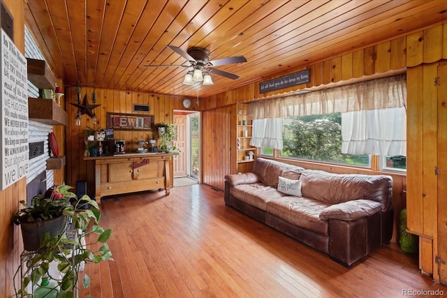 living room with ceiling fan, wooden ceiling, wood walls, hardwood / wood-style floors, and a fireplace