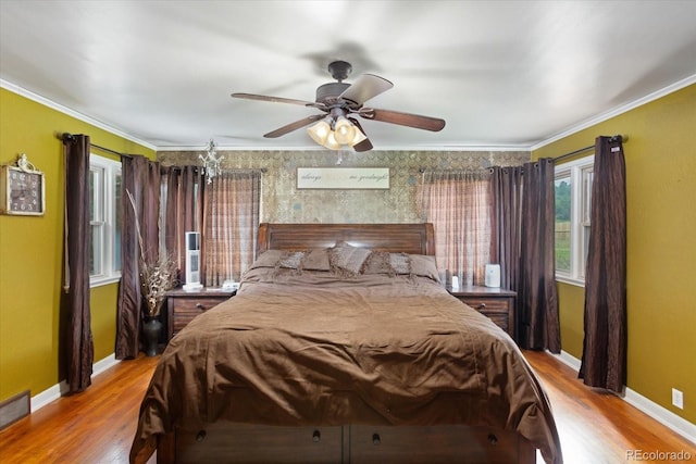 bedroom with crown molding, ceiling fan, and light hardwood / wood-style floors