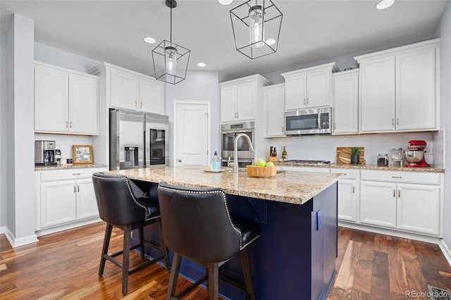 kitchen featuring appliances with stainless steel finishes, tasteful backsplash, white cabinetry, and recessed lighting