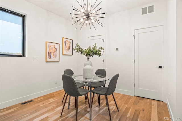 dining room featuring hardwood / wood-style flooring and an inviting chandelier