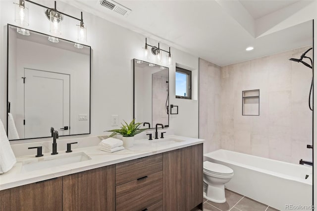 full bathroom featuring tile patterned floors, toilet, tiled shower / bath combo, and vanity