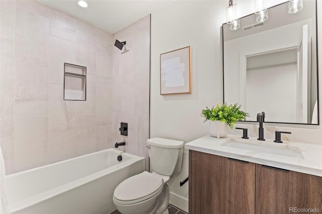 full bathroom with vanity, tiled shower / bath combo, and toilet