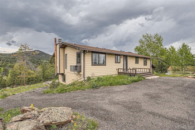 30839 Manitoba Dr, Evergreen, CO 80439 - ranch-style house featuring a chimney, a deck, and cooling unit