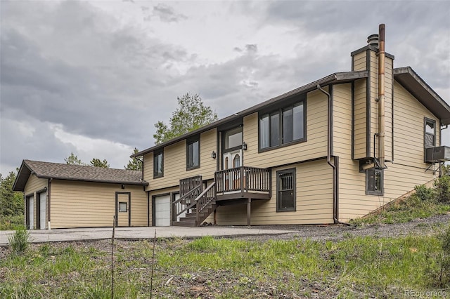 30839 Manitoba Dr, Evergreen, CO 80439 - rear view of house with a chimney, driveway, cooling unit, and an attached garage