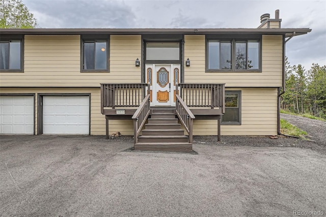 30839 Manitoba Dr, Evergreen, CO 80439 - bi-level home featuring an attached garage and asphalt driveway