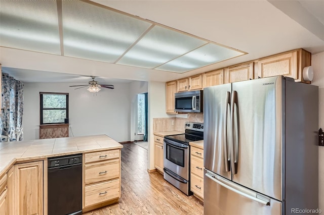 30839 Manitoba Dr, Evergreen, CO 80439 - kitchen featuring stainless steel appliances, light brown cabinetry, tile counters, and tasteful backsplash