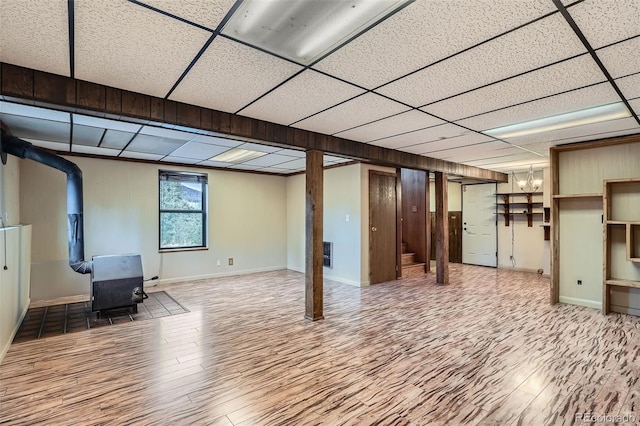 30839 Manitoba Dr, Evergreen, CO 80439 - below grade area featuring a wood stove, wood finished floors, a drop ceiling, a chandelier, and stairway