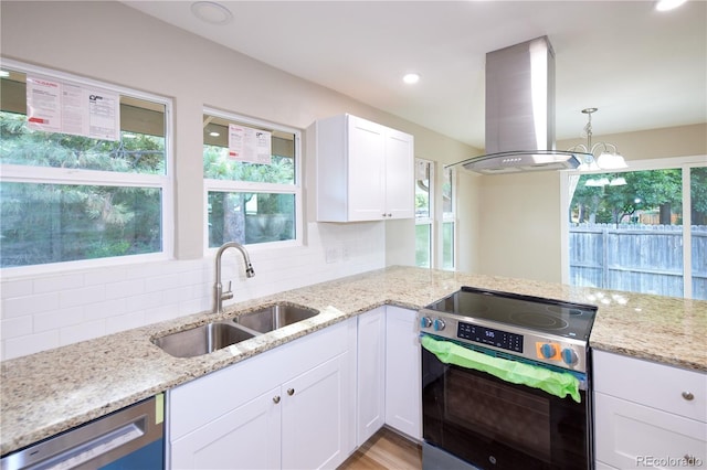8713 E Roundtree Ave, Greenwood Village, CO 80111 - kitchen featuring stainless steel appliances, island exhaust hood, plenty of natural light, light stone counters, and recessed lighting