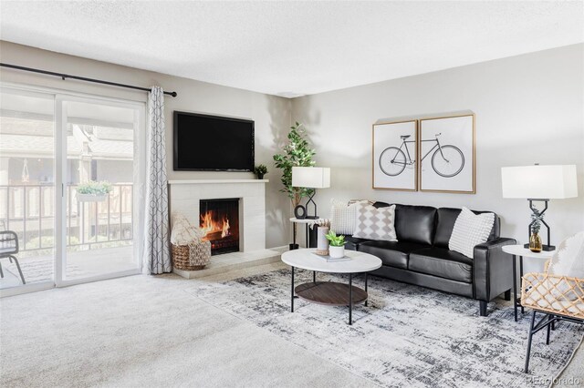 carpeted living area with a brick fireplace and a textured ceiling