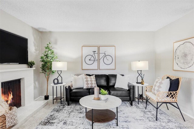 living area with baseboards, a fireplace, and a textured ceiling