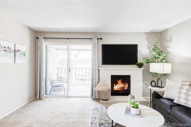 living room with carpet floors, a fireplace, baseboards, and a textured ceiling