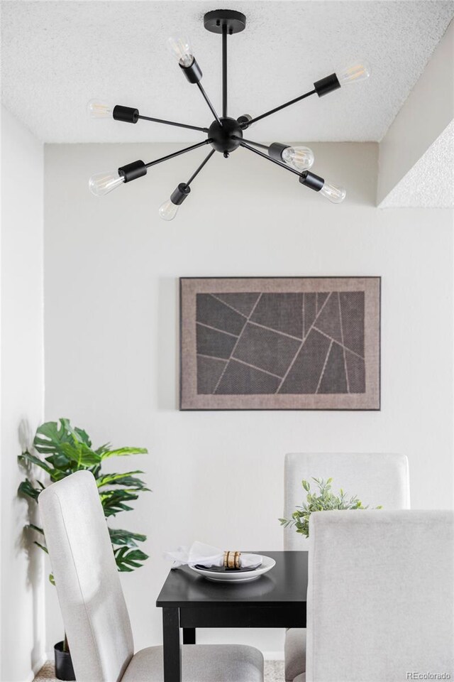 dining area with a chandelier and a textured ceiling