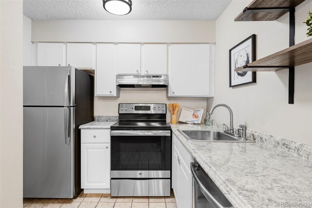 kitchen featuring under cabinet range hood, appliances with stainless steel finishes, a sink, white cabinets, and a textured ceiling