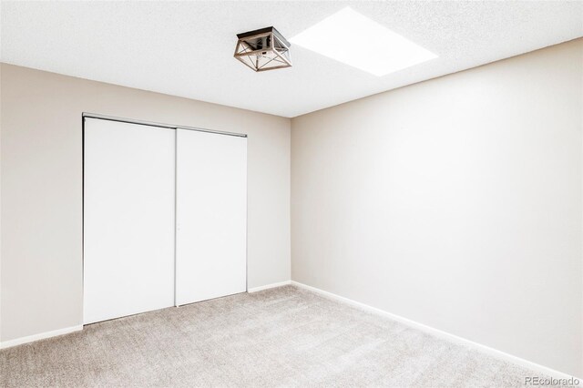 unfurnished bedroom featuring carpet floors, a closet, and baseboards