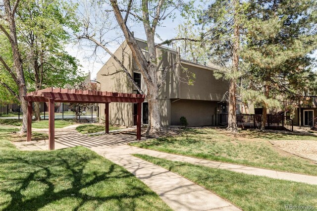 rear view of house with a pergola and stucco siding