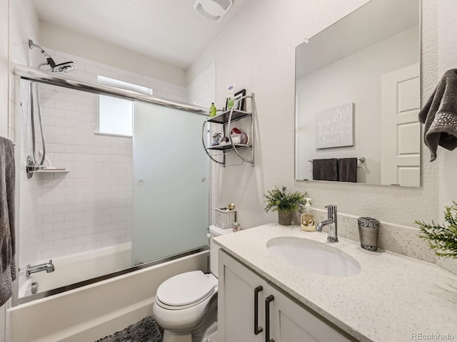 full bathroom with bath / shower combo with glass door, toilet, and vanity