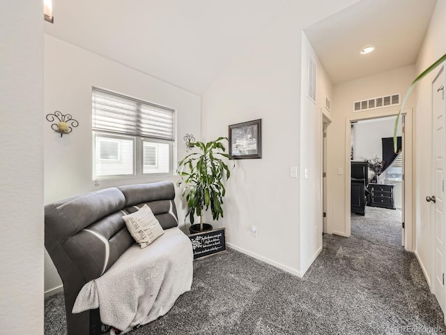 living area featuring vaulted ceiling and dark colored carpet