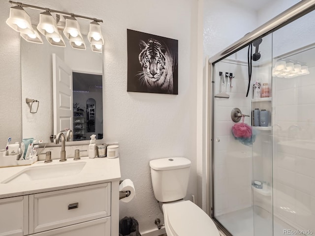 bathroom with an enclosed shower, vanity, and toilet