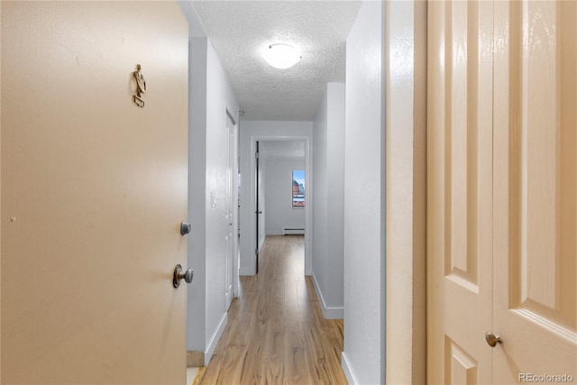 hall with light wood finished floors, a textured ceiling, baseboards, and a baseboard radiator