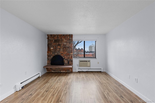 unfurnished living room with light wood finished floors, a stone fireplace, a textured ceiling, and a baseboard heating unit