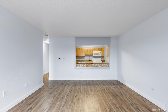 unfurnished living room featuring baseboards and wood finished floors