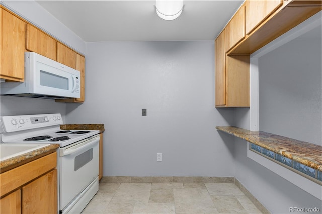 kitchen featuring white appliances and baseboards