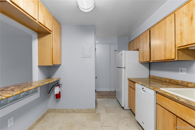 kitchen with white appliances, light tile patterned flooring, baseboards, and a sink