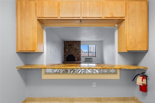 kitchen with a textured ceiling and a fireplace