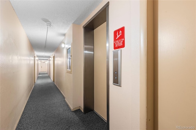 corridor with elevator, carpet, and a textured ceiling