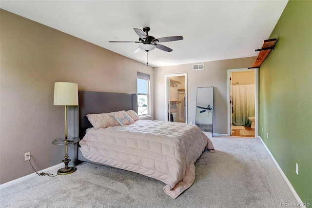 carpeted bedroom featuring a walk in closet, ceiling fan, a closet, and ensuite bath