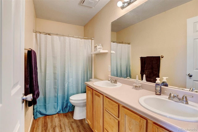 bathroom with hardwood / wood-style floors, vanity, and toilet