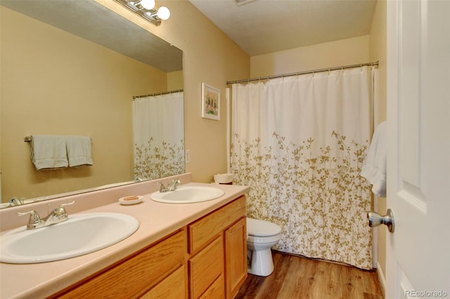 bathroom with hardwood / wood-style floors, vanity, and toilet