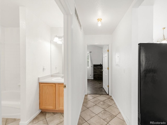 1748 Eagle St Unit B, Aurora, CO 80011 - hallway with baseboards, visible vents, light tile patterned flooring, and a sink