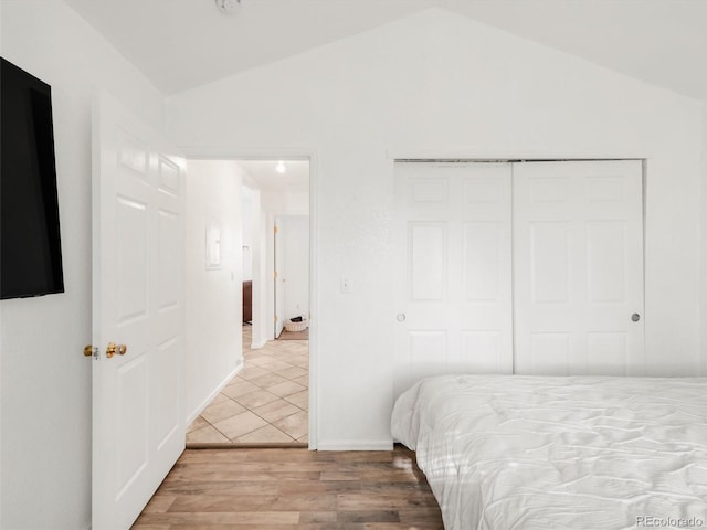 1748 Eagle St Unit B, Aurora, CO 80011 - bedroom with a closet, wood finished floors, and vaulted ceiling