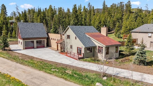 475 Vail Cir, Dillon, CO 80435 - view of front of house with a chimney, an outdoor structure, driveway, and a shingled roof