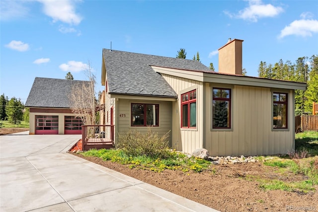 475 Vail Cir, Dillon, CO 80435 - view of front of home with a chimney, concrete driveway, roof with shingles, and a garage