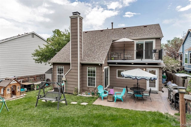 573 Entrada Dr, Golden, CO 80401 - back of property with a balcony, a shingled roof, a patio area, and a chimney