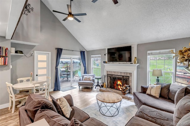 573 Entrada Dr, Golden, CO 80401 - living area with high vaulted ceiling, a ceiling fan, a fireplace, wood finished floors, and a textured ceiling