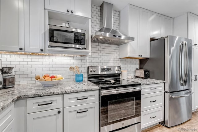 573 Entrada Dr, Golden, CO 80401 - kitchen with wall chimney exhaust hood, stainless steel appliances, white cabinetry, and backsplash