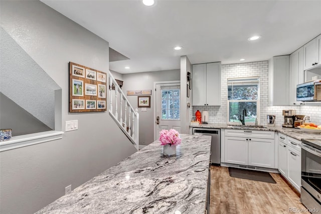 573 Entrada Dr, Golden, CO 80401 - kitchen with a sink, appliances with stainless steel finishes, tasteful backsplash, light stone countertops, and healthy amount of natural light