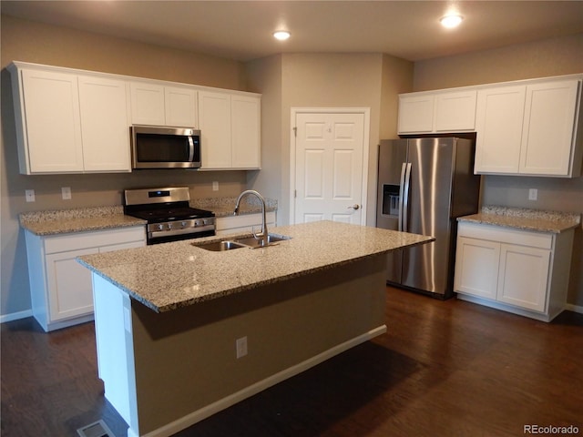 kitchen featuring stainless steel appliances, dark wood-type flooring, sink, a center island with sink, and white cabinetry