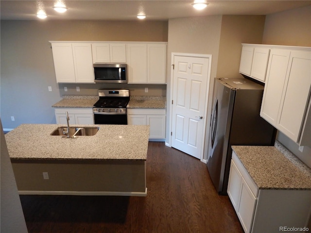 kitchen featuring sink, an island with sink, light stone counters, white cabinetry, and stainless steel appliances