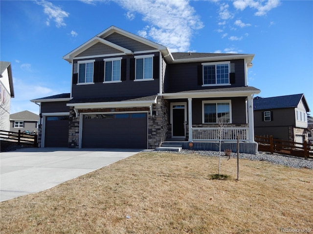 view of front of home featuring fence, an attached garage, covered porch, concrete driveway, and stone siding