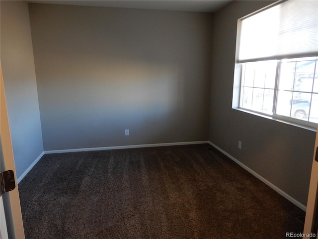 empty room featuring dark carpet