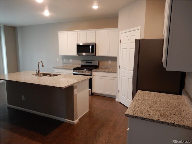 kitchen featuring white cabinetry, sink, dark hardwood / wood-style floors, an island with sink, and appliances with stainless steel finishes