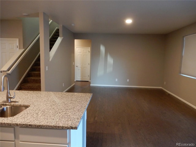 kitchen featuring light stone countertops, sink, white cabinets, and dark hardwood / wood-style floors