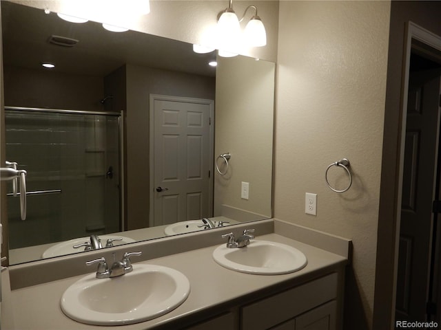 bathroom with vanity and a shower with door