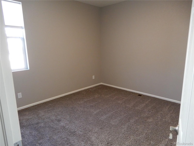 unfurnished room with dark carpet