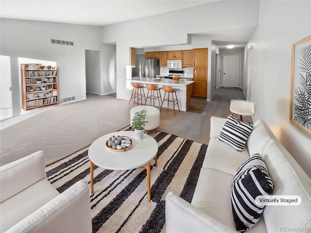 carpeted living room with vaulted ceiling